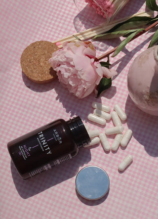 Product photo of our TRINITY night formula next to a rose